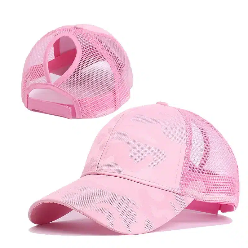 Deux casquettes CamSolomon en maille camouflage rose de la ligne La Casquette Tendance Spéciale Chignon sont présentées. Lune est présentée de profil avec sa visière incurvée, et lautre dévoile une ouverture élastique à larrière, idéale pour une femme fatale en déplacement.